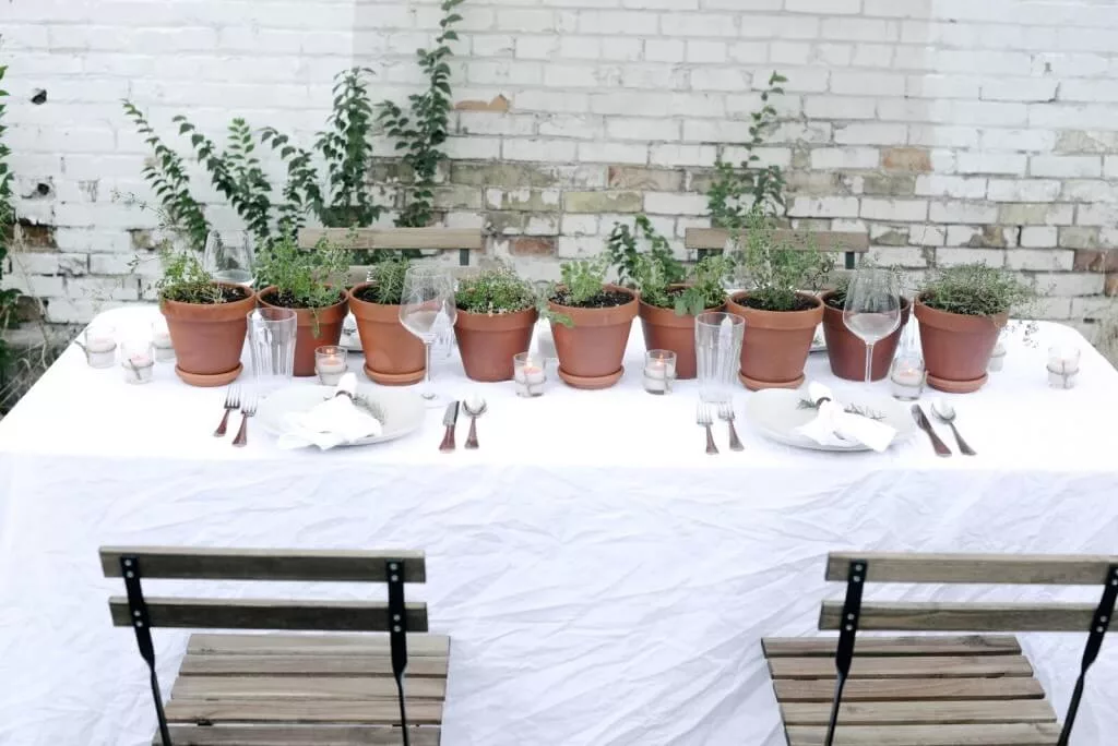 herbs in at pot in a summer tablescape for outdoor dining table