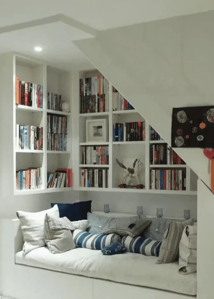 library with reading nook built into the space under the stairs