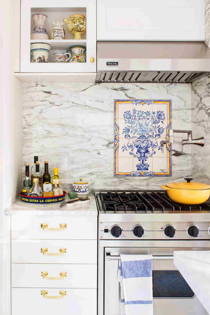 Black and white kitchen backsplash with marble tiles and colorful vintage kitchen accessories